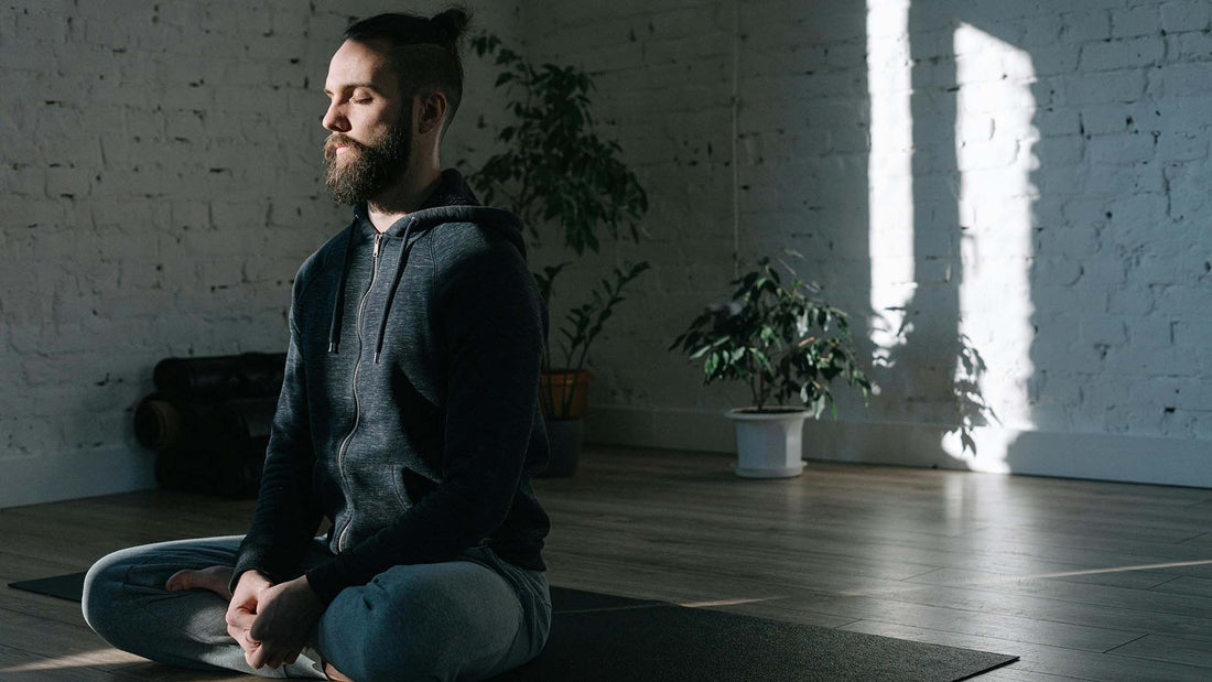 a man concentrating while doing yoga indoors