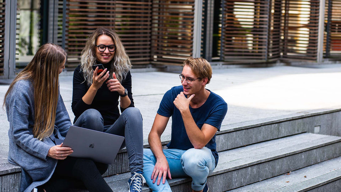 three friends sitting on steps and talking