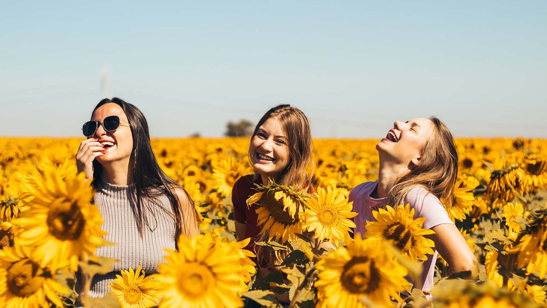 three happy women in a field of sunflowers