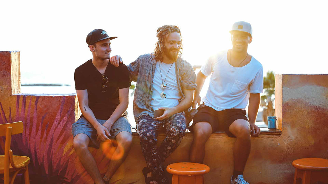 three man hanging out and sitting on a bench