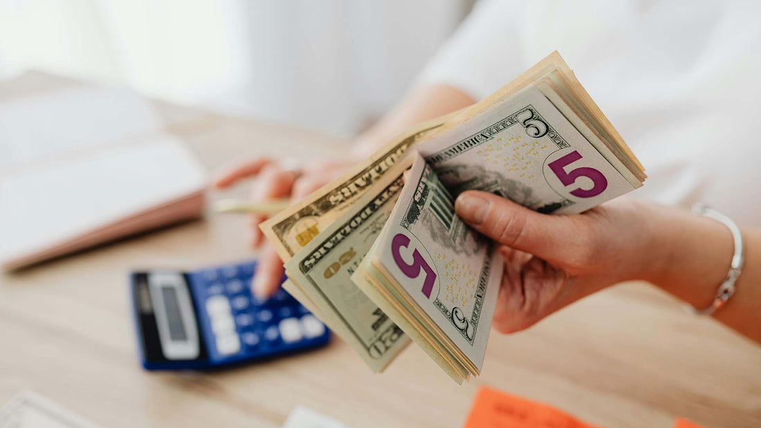 Person holding cash while using a calculator