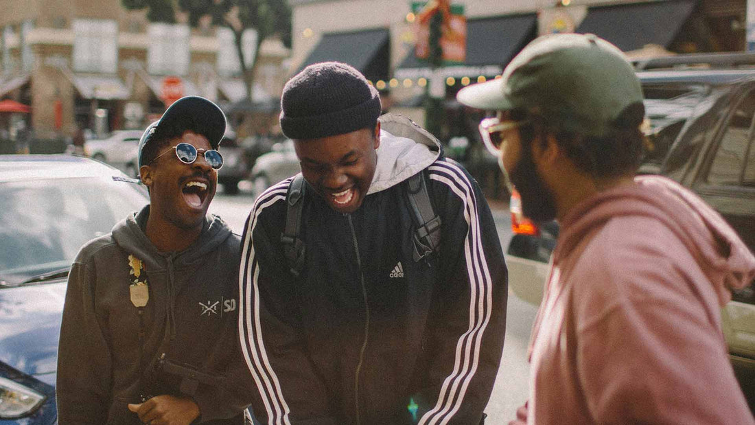 three men hanging out in the streets and laughing