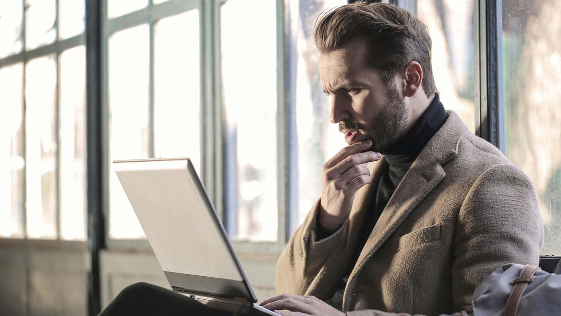 Confused man looking at a laptop