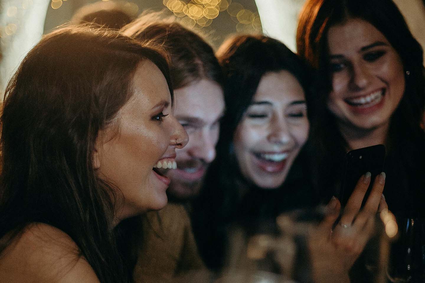 Group of women looking at a phone and laughing