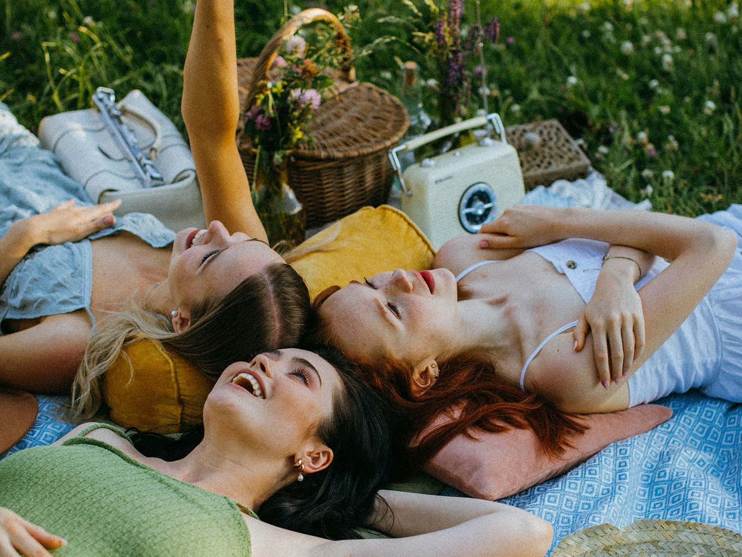 group of friends lying on a picnic blanket