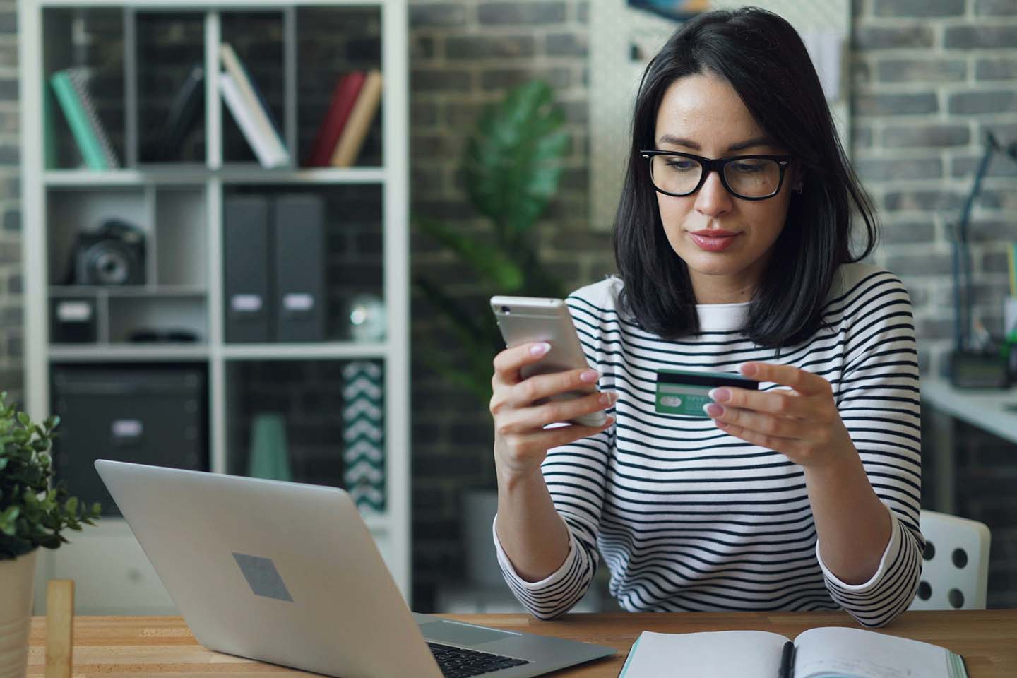 woman sitting at a table looking at her cell phone