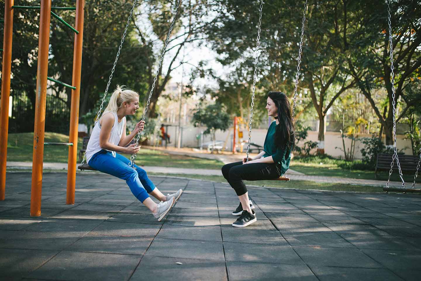 two women sitting on swing