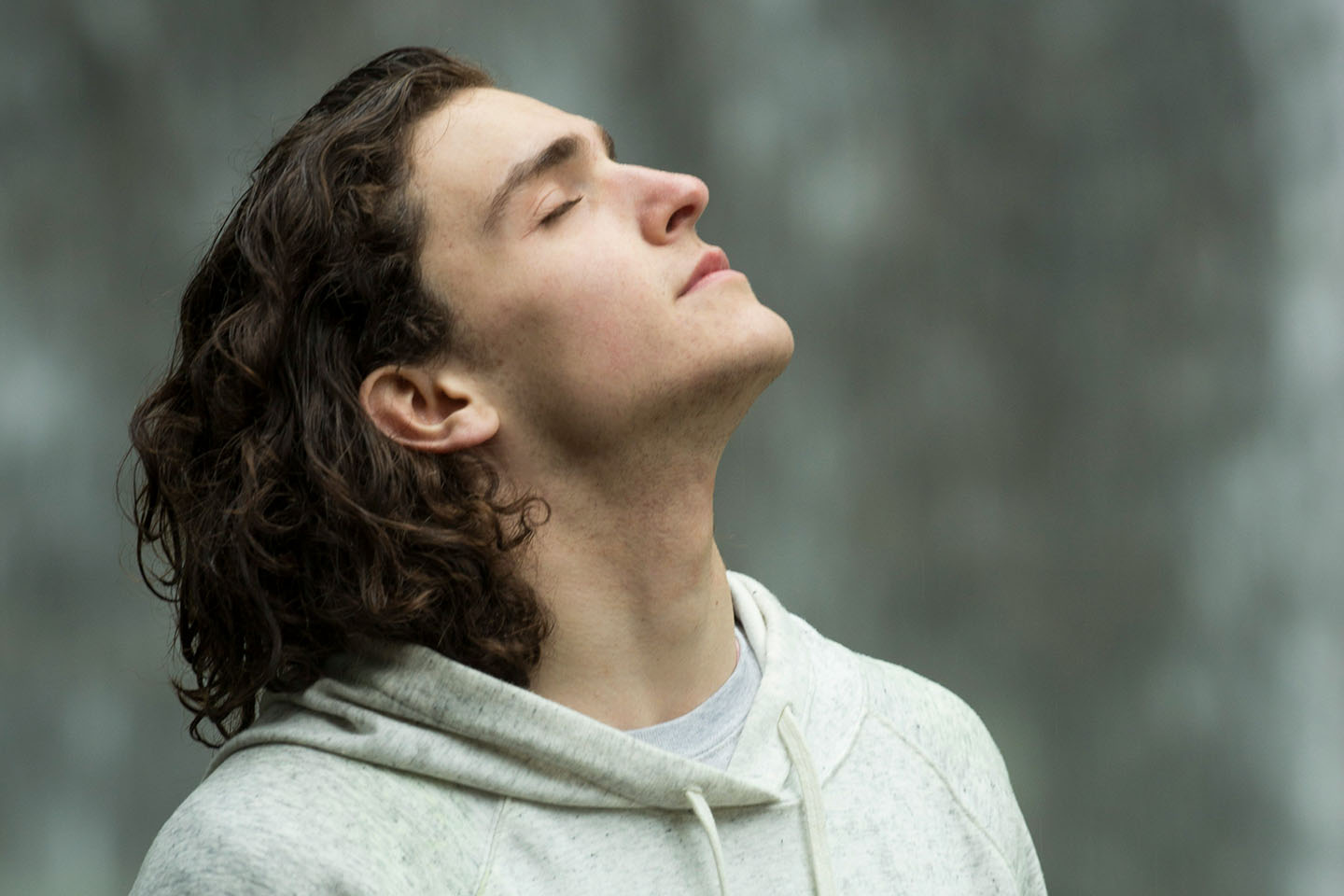 man in grey hoodie breathing in fresh air