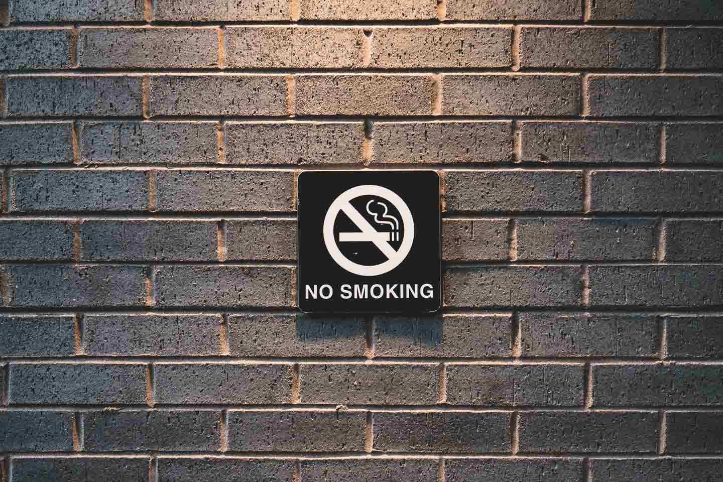 black no smoking sign on a brick wall