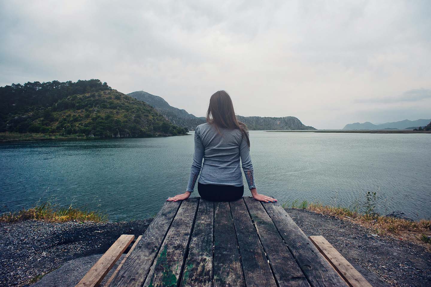 Women sitting on a bench facing a lake